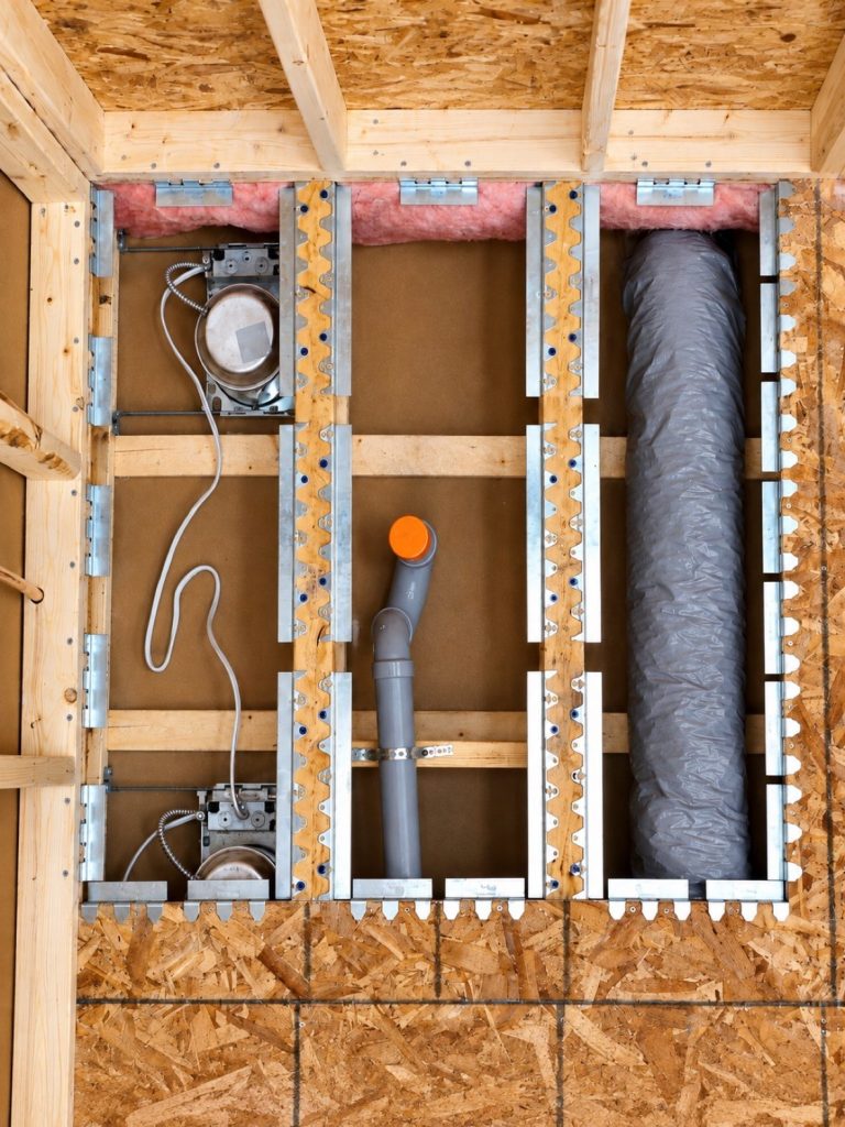Schluter KERDI-SHOWER-FRS floor recessing brackets installed between joists from below, plumbing and duct untouched