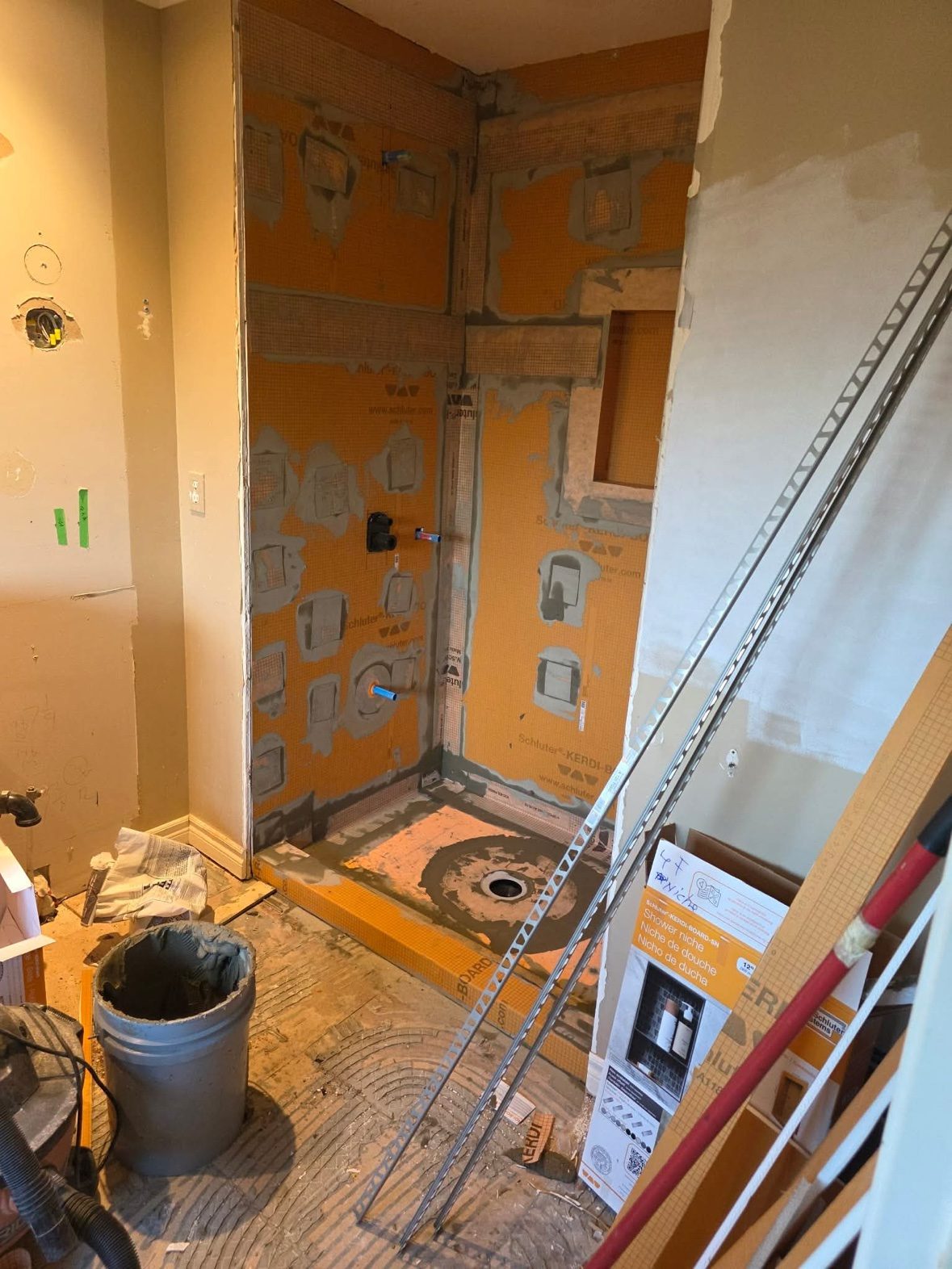 Schluter KERDI-BOARD waterproofing going in before tile — the part of the job nobody sees, done once and done right