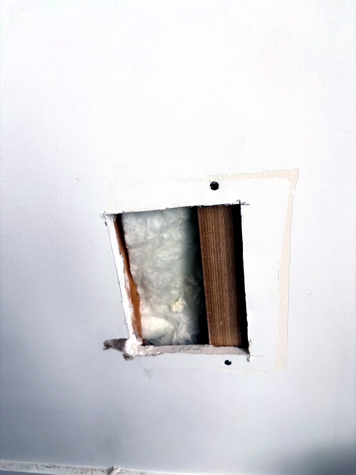 Wood backing strips behind small drywall repair opening