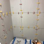 Close-up of tile levelling clips between large-format tiles