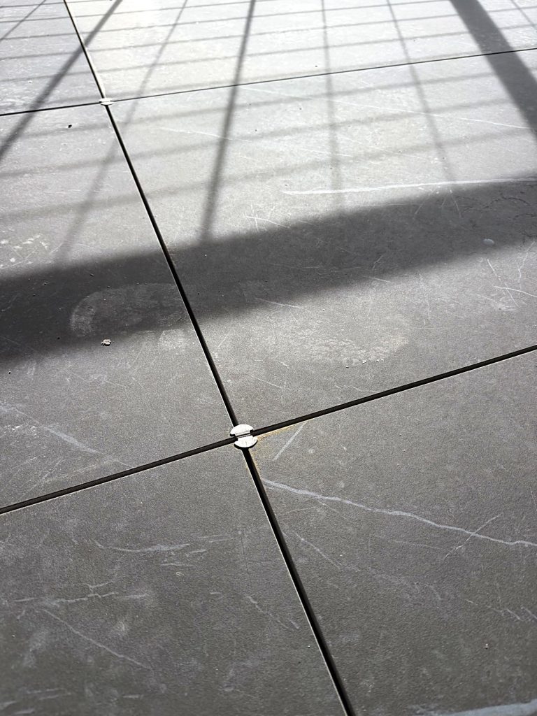 Stainless steel spacer between porcelain pavers Burnaby balcony